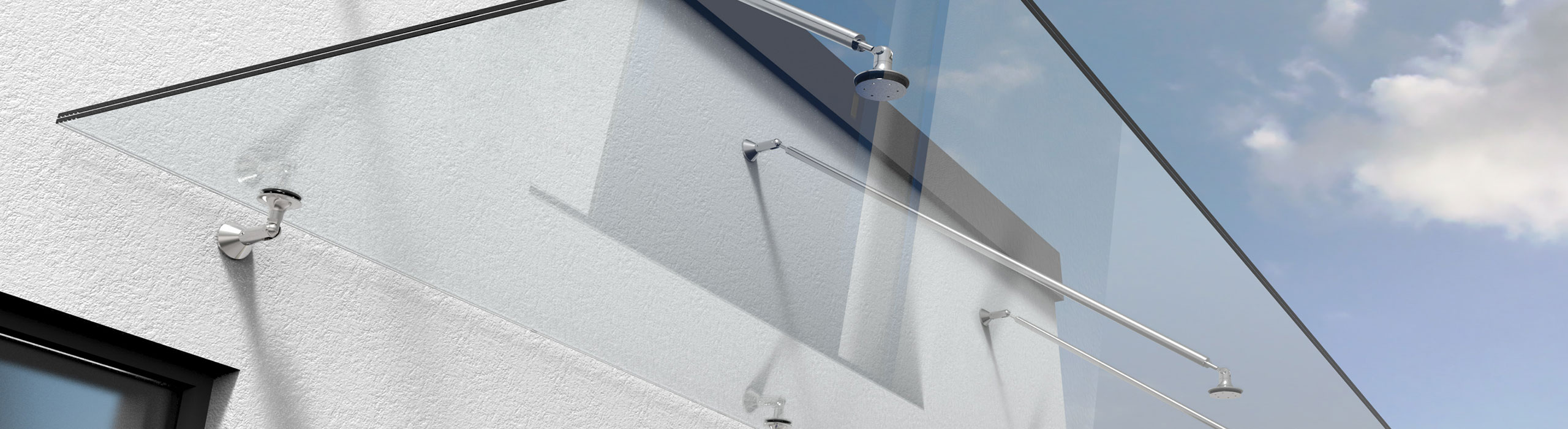 Ein Glasvordach hängt an einer hellen Hausfassade.