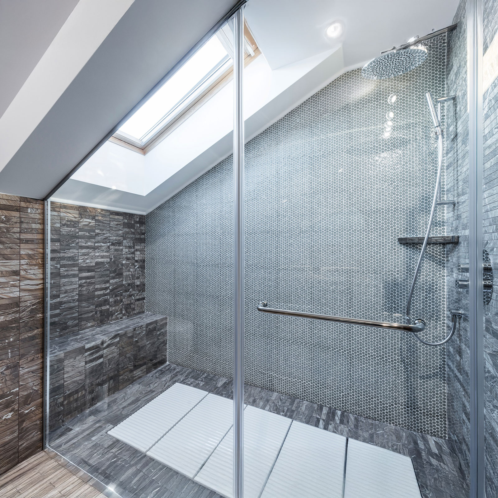 Ein modernes Badezimmer mit Dachschräge, in der eine große Walk-in-Dusche installiert wurde.