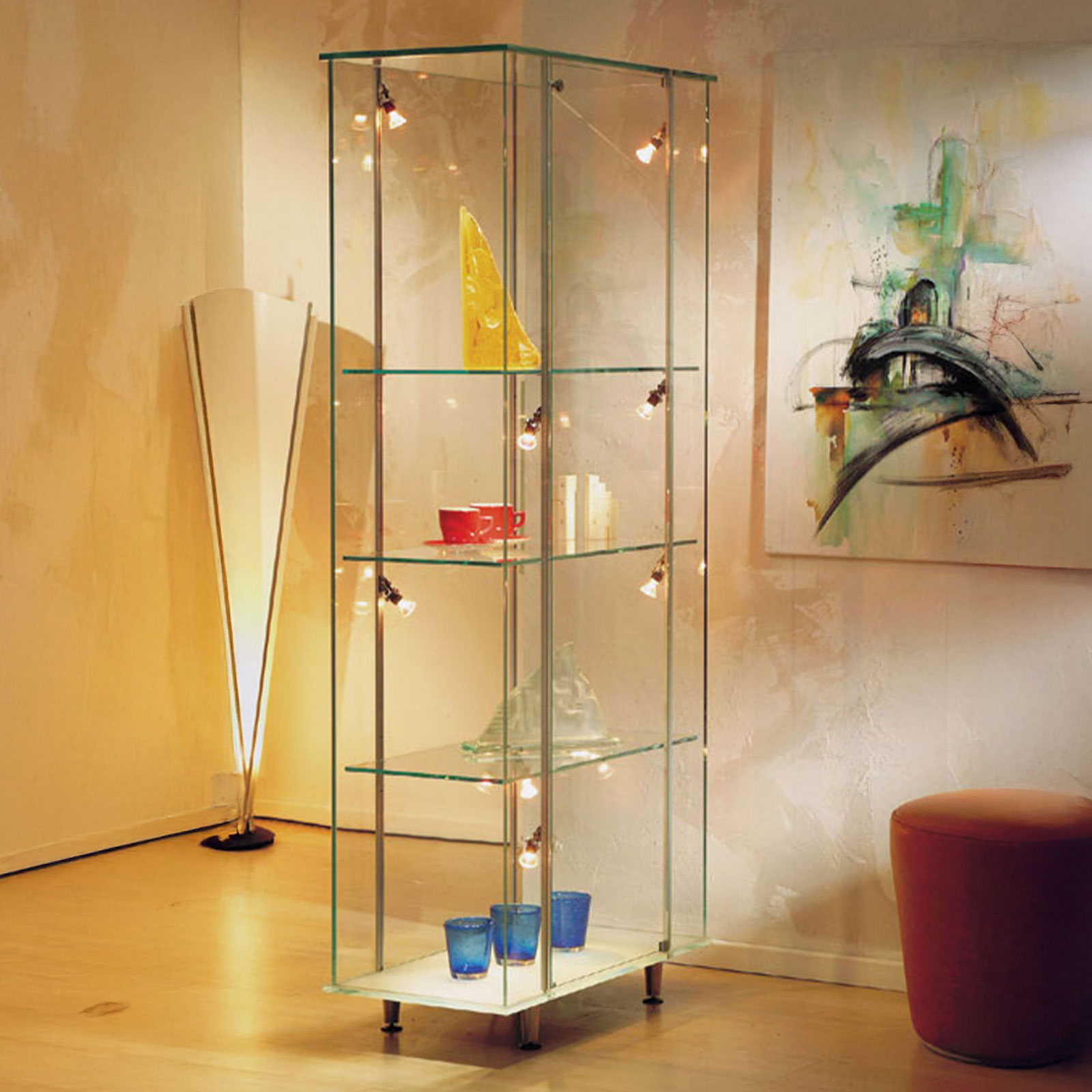 In einem sanft beleuchtetem Raum steht ein Glasvitrine, die verschiedene Gegenstände beinhaltet.
