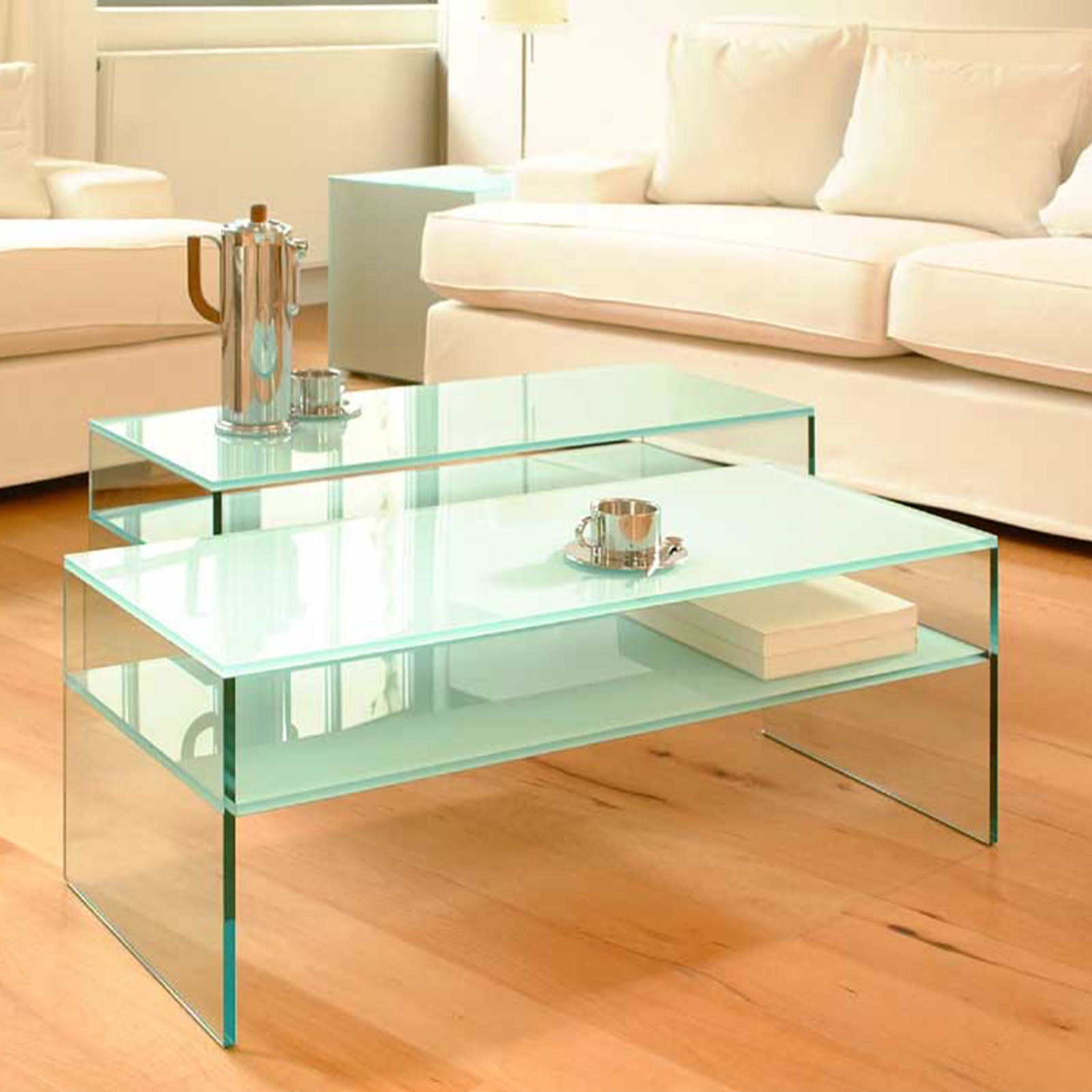 In einem Wohnzimmer stehen zwei Couchtische, die komplett aus Glas bestehen.